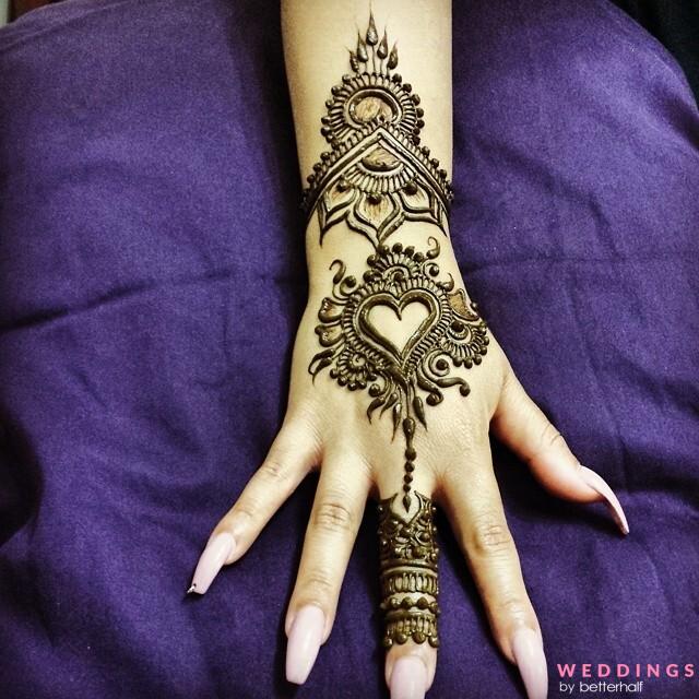 Photo of beautiful heart-shaped henna mehndi design on back hand