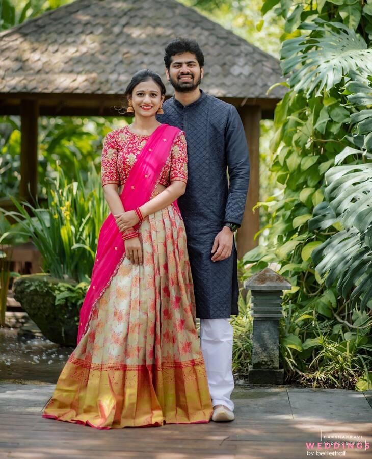 Capture the essence of love as a couple dressed in traditional attire pose near a gazebo.