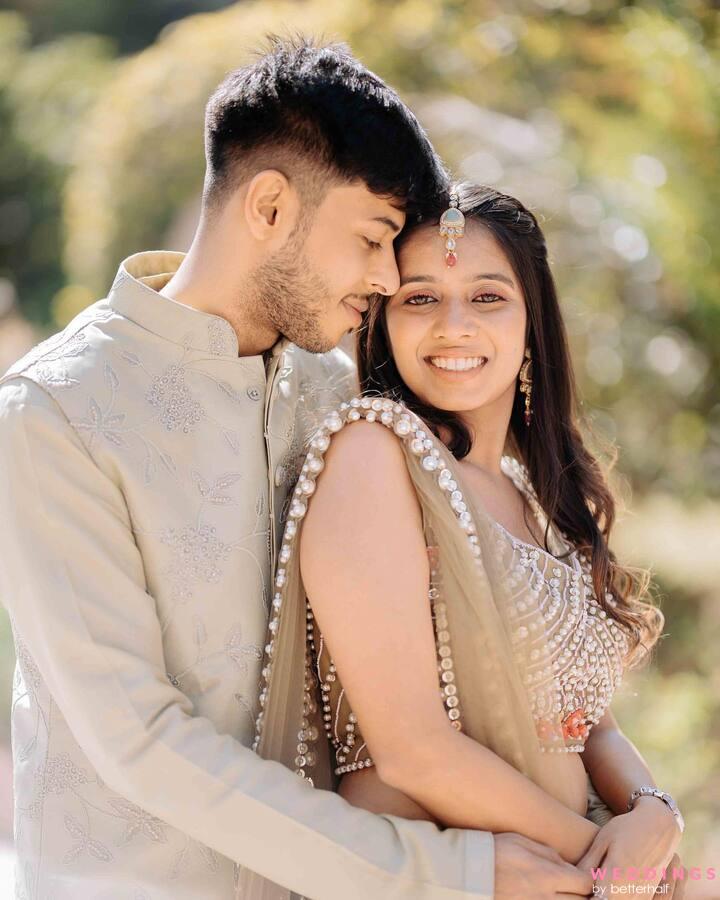 An intimate photo of an Indian couple posing amidst trees, exuding love and elegance.