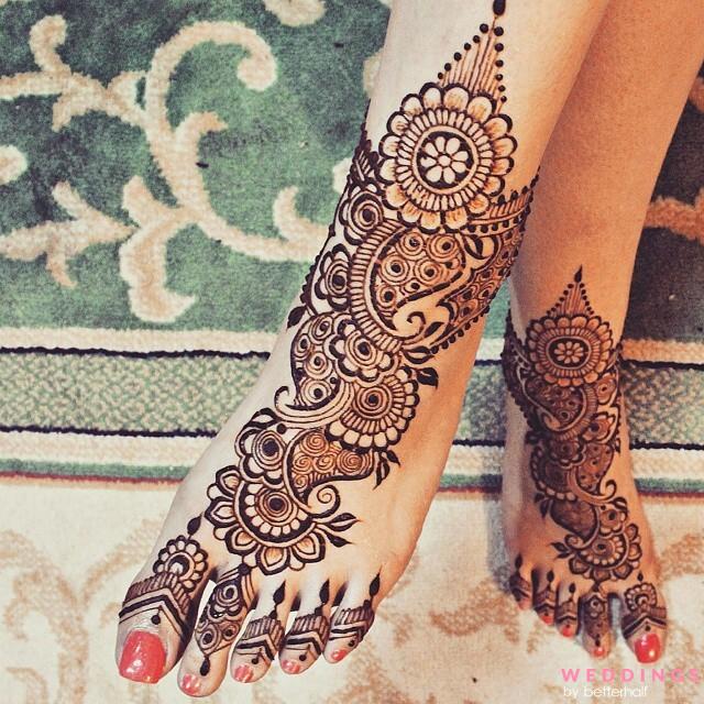 Foot adorned with bridal Arabic mehndi design, featuring intricate floral and spiral designs.