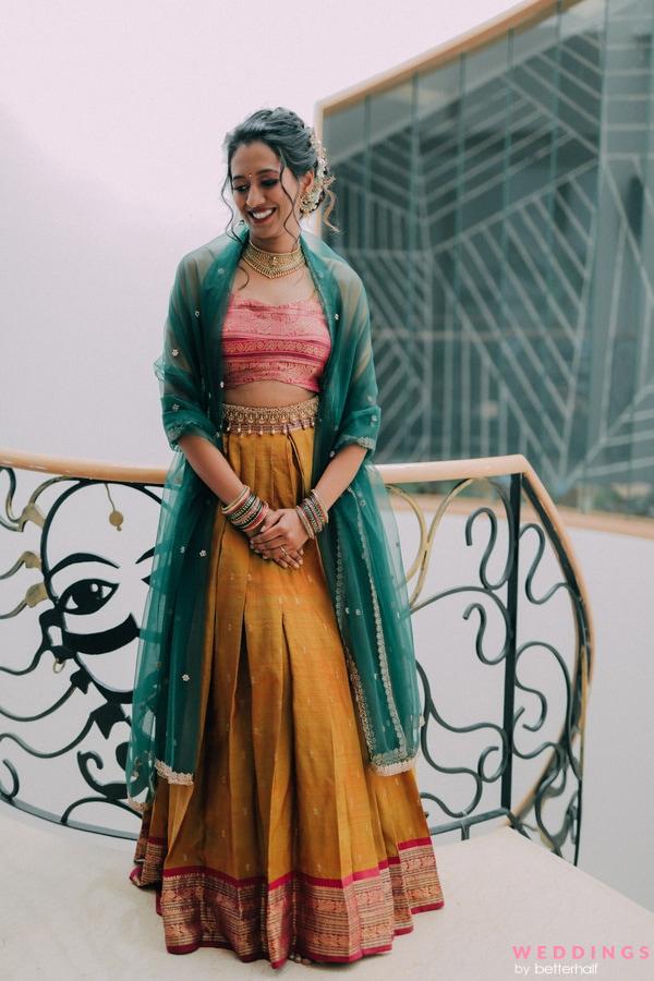 Capture the beauty of this woman in a traditional Indian outfit on a picturesque balcony. Explore simple and South Indian bridal lehenga ideas.