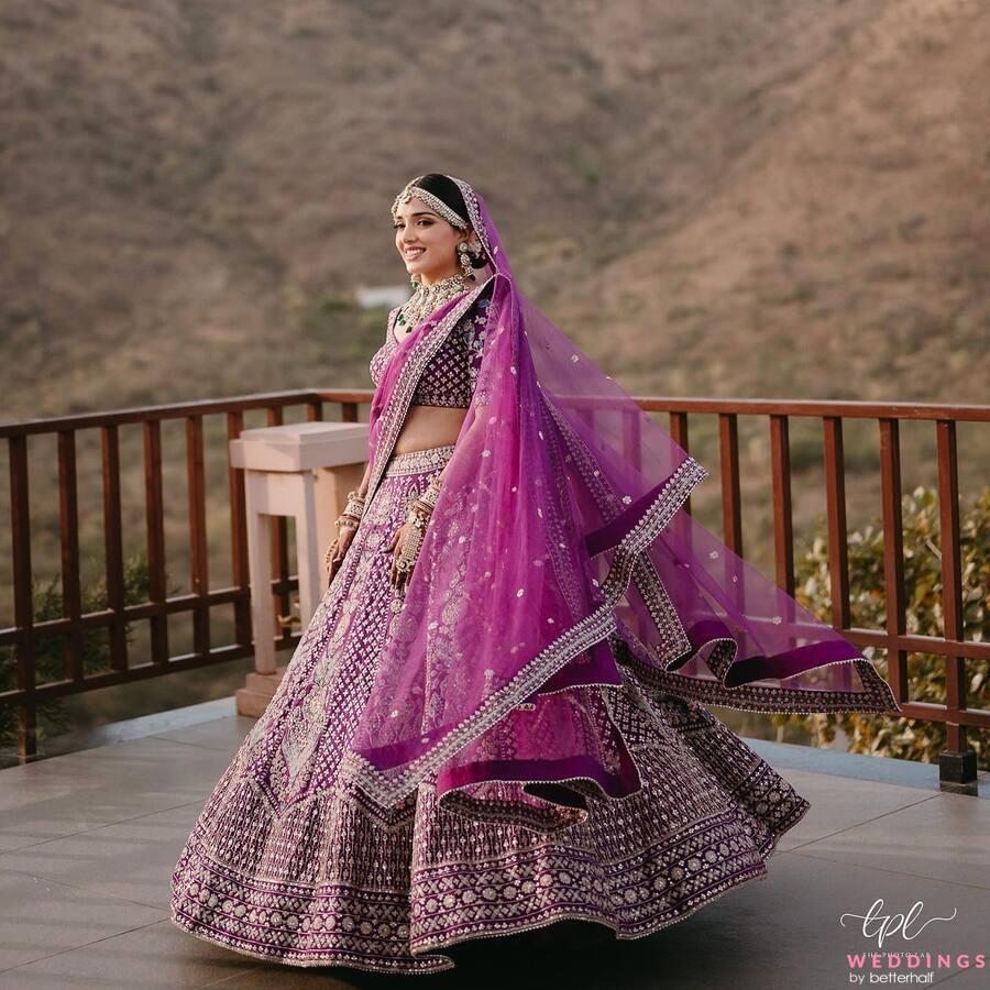 Experience the beauty of an Indian wedding with this stunning purple lehenga. Find more bridal lehenga and photoshoot pose ideas in our ideabook!