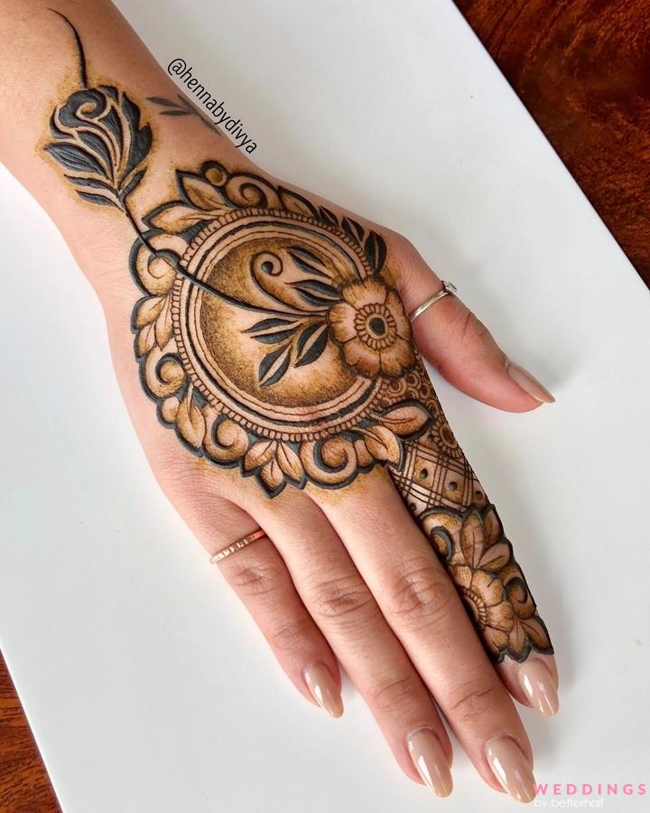 Photo of simple floral mehendi design  on a woman's backhand