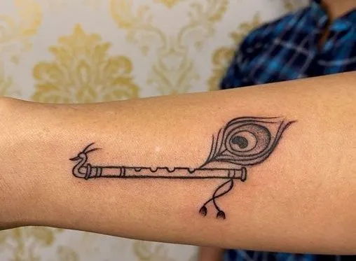 Photo of Krishna’s flute with a mor pankh on it for your wrist